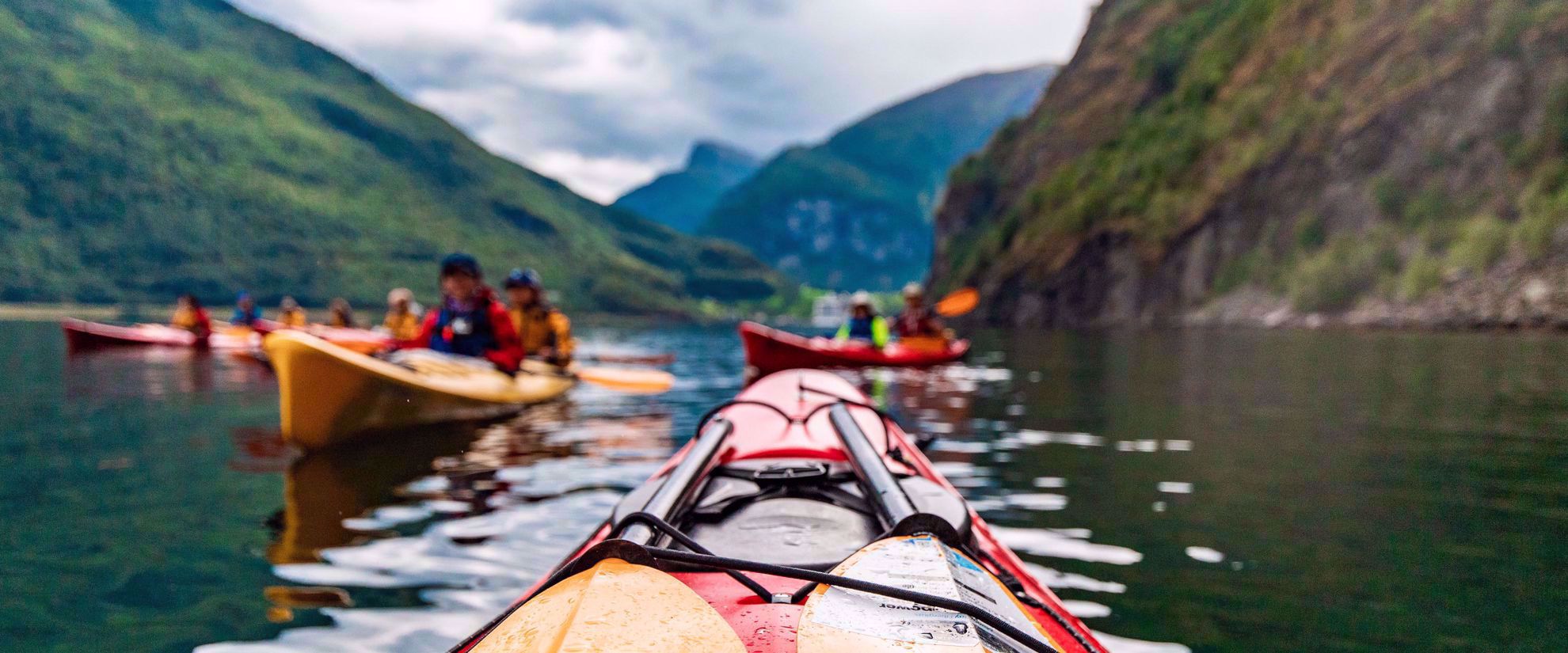 kayaking through lake in norway group women's travel adventure