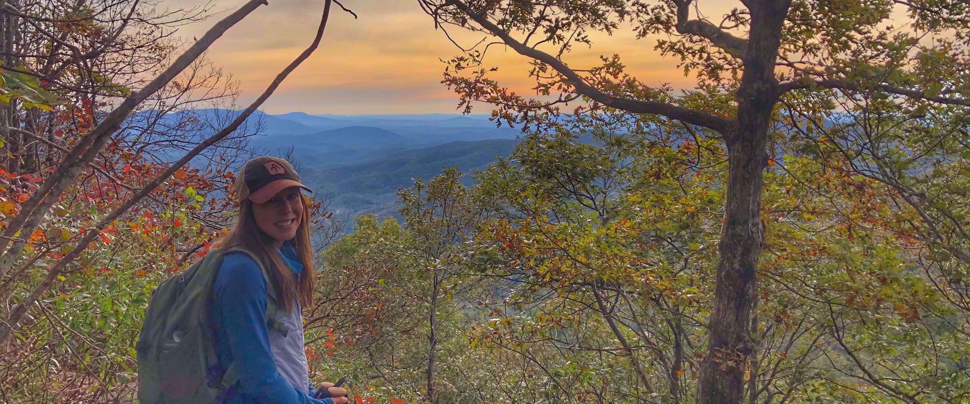 woman smiles for photo on fall hike in georgia