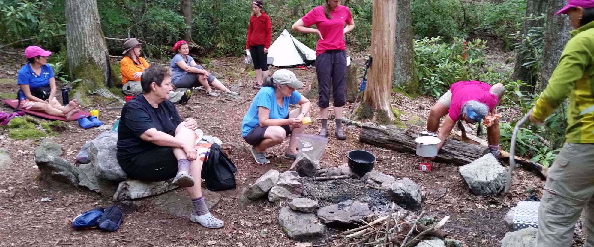 female travel group making breakfast on appalachian trail after camping