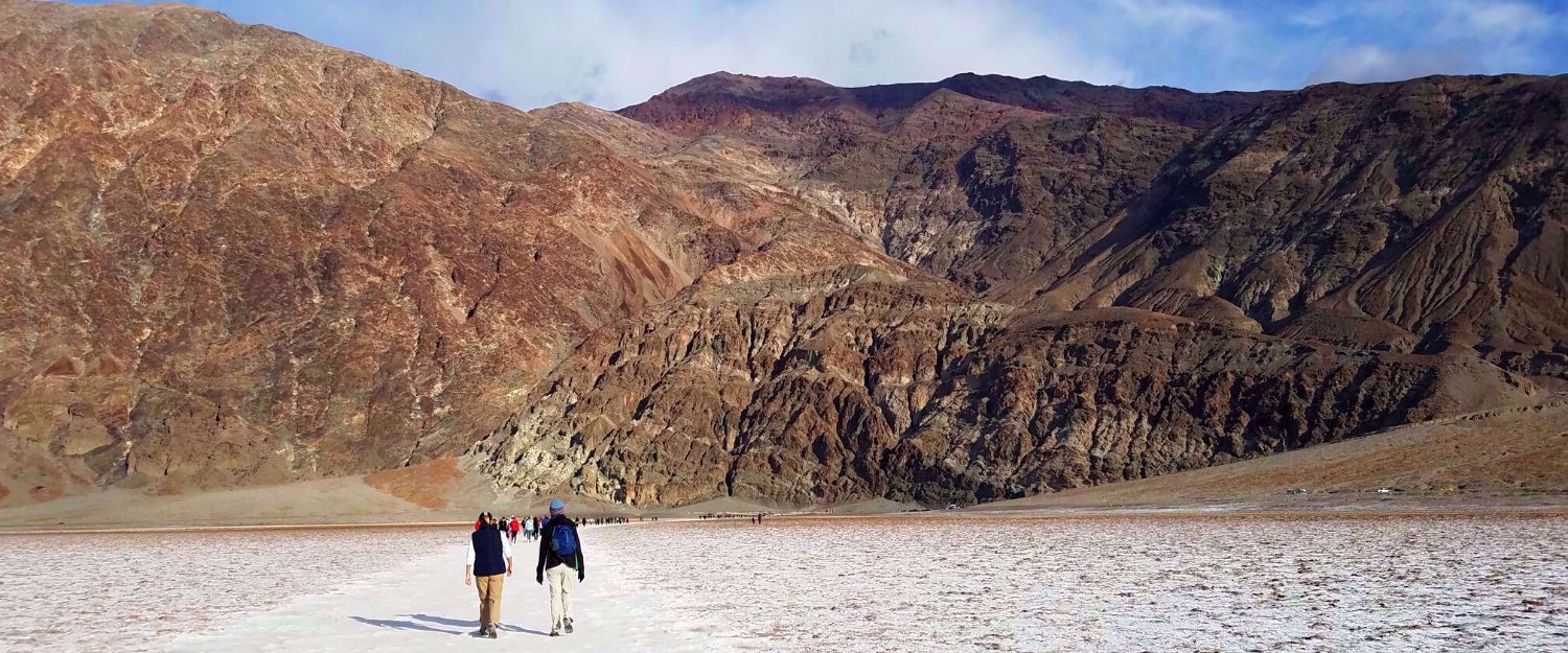 women hiking death valley rock formation